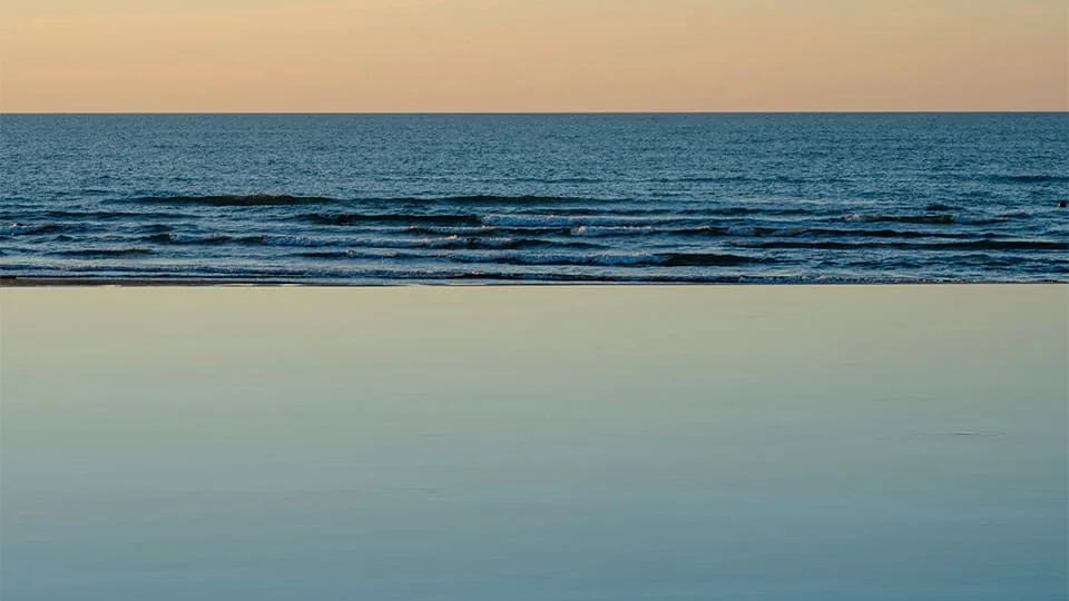 White Beach çimərliyindən qürubda Xəzər — üfüqə qədər işıq zolağı